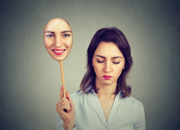 Depressed woman handing happy face
